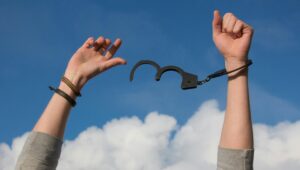 Home Symbolic image of freedom with open handcuffs against a bright blue sky.
