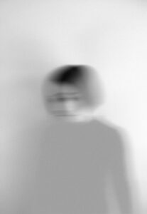 Home Artistic blurred grayscale portrait capturing motion and emotion.